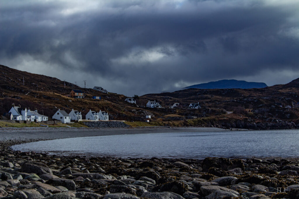 A village of a few cottages along the coastline in the Highlands.